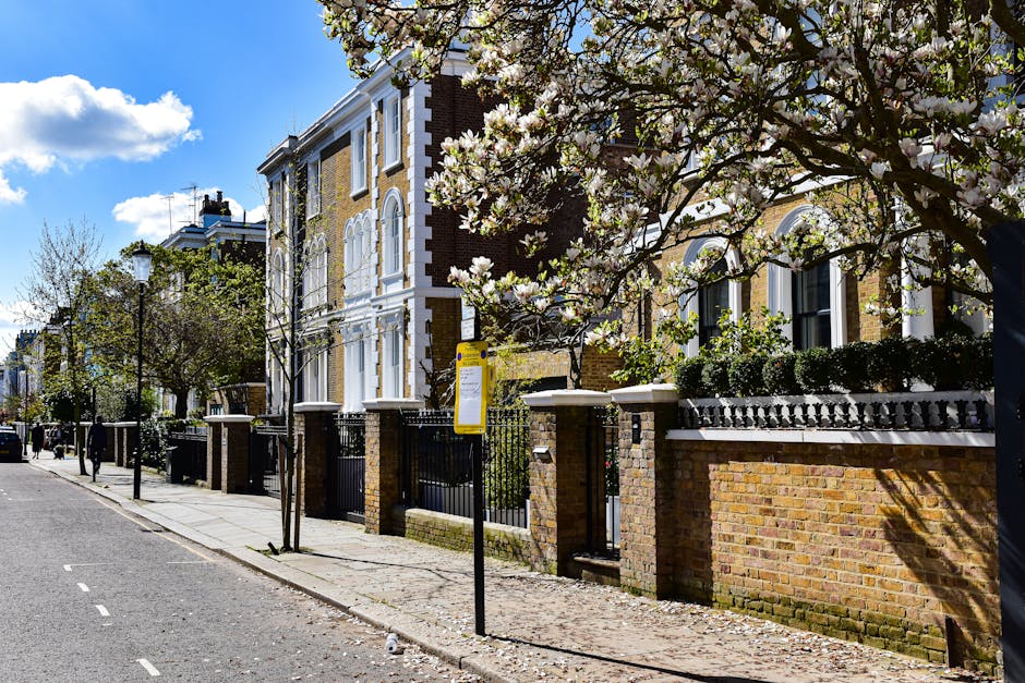A row of Victorian-style brick houses along Tottenham High Road, featuring white decorative window frames and ornate cornices, with well-maintained gardens enclosed by low brick walls and black wrough